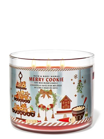 Svíčka „Merry Cookie“ v nádobě s ilustracemi vánočního cukroví, věnce a perníkové chaloupky, Bath & Body Works.