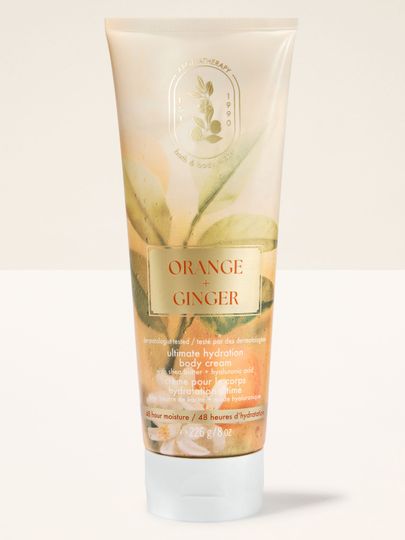 Cremă de corp Bath & Body Works Aromatherapy Orange + Ginger 226 g, în tub deschis cu decor vegetal.