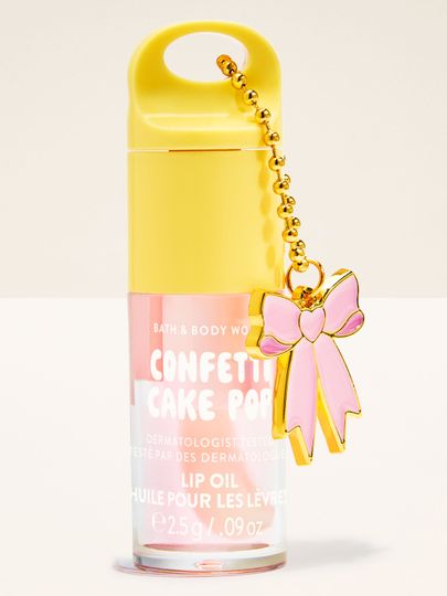 Ulei de buze Bath & Body Works Confetti Cake Pop 2,5 g, în ambalaj pastel cu breloc decorativ tip fundă.