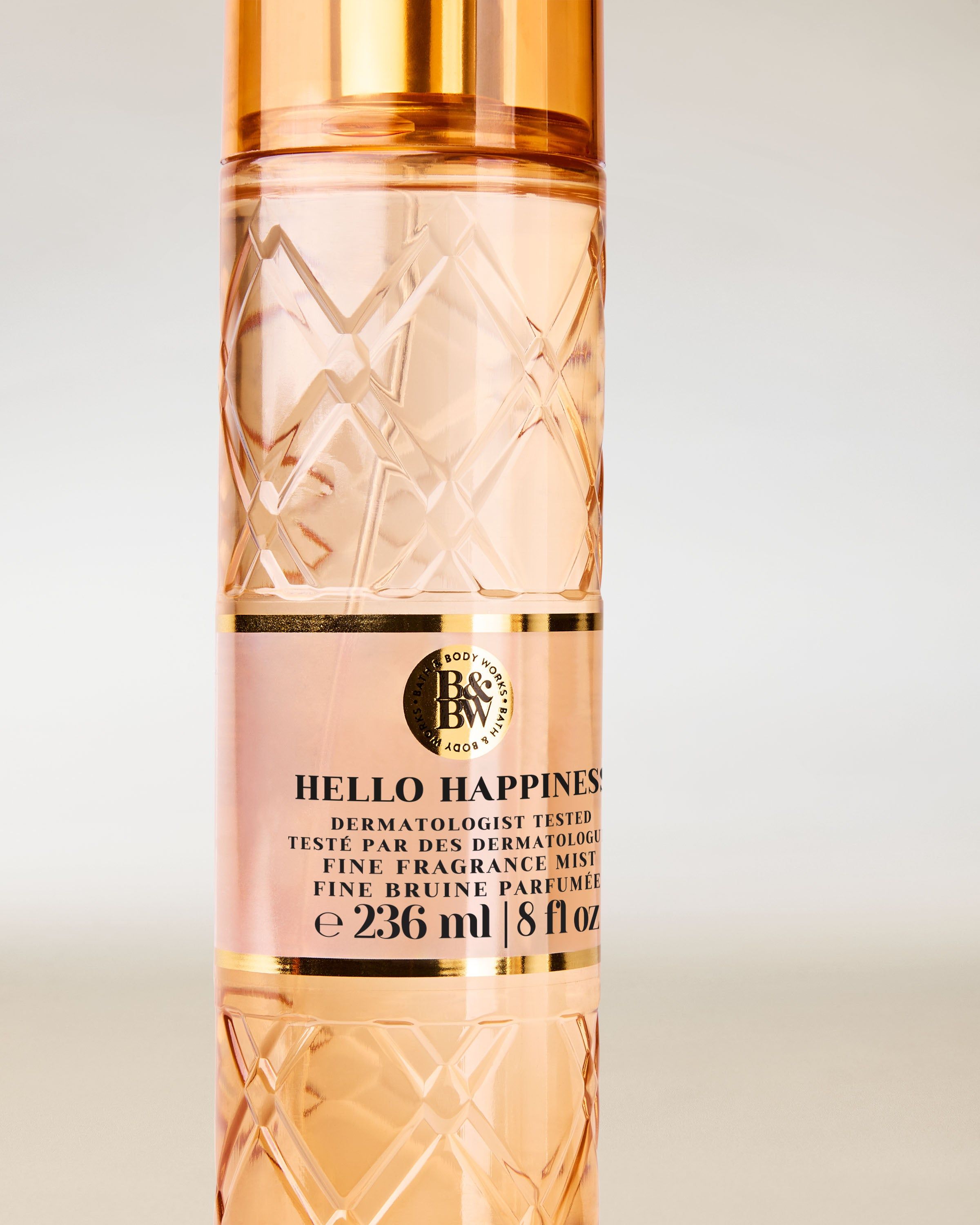 Bath & Body Works Hello Happiness – spray în sticlă texturată piersicie cu pulverizator auriu.