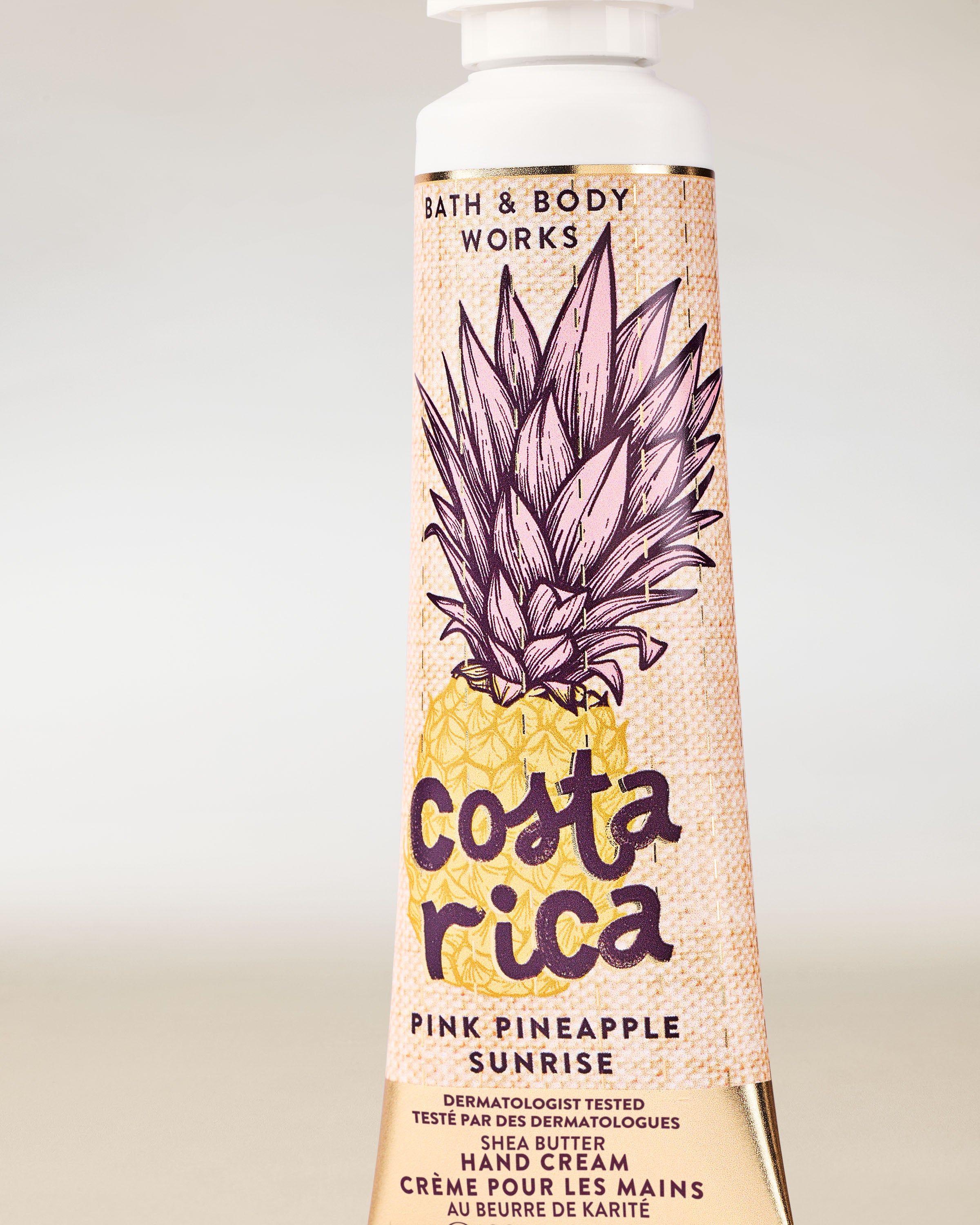 Cremă de mâini Costa Rica Pink Pineapple Sunrise în tub galben, cu ilustrație de ananas și motiv tropical.