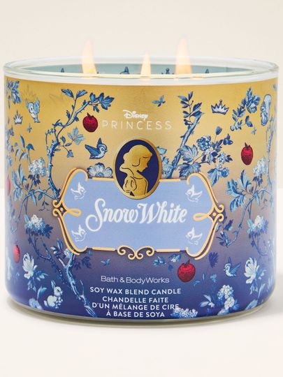 Lumânarea Snow White cu 3 fitiluri, în ambalaj auriu‑albastru cu mere, păsărele și detalii regale.
