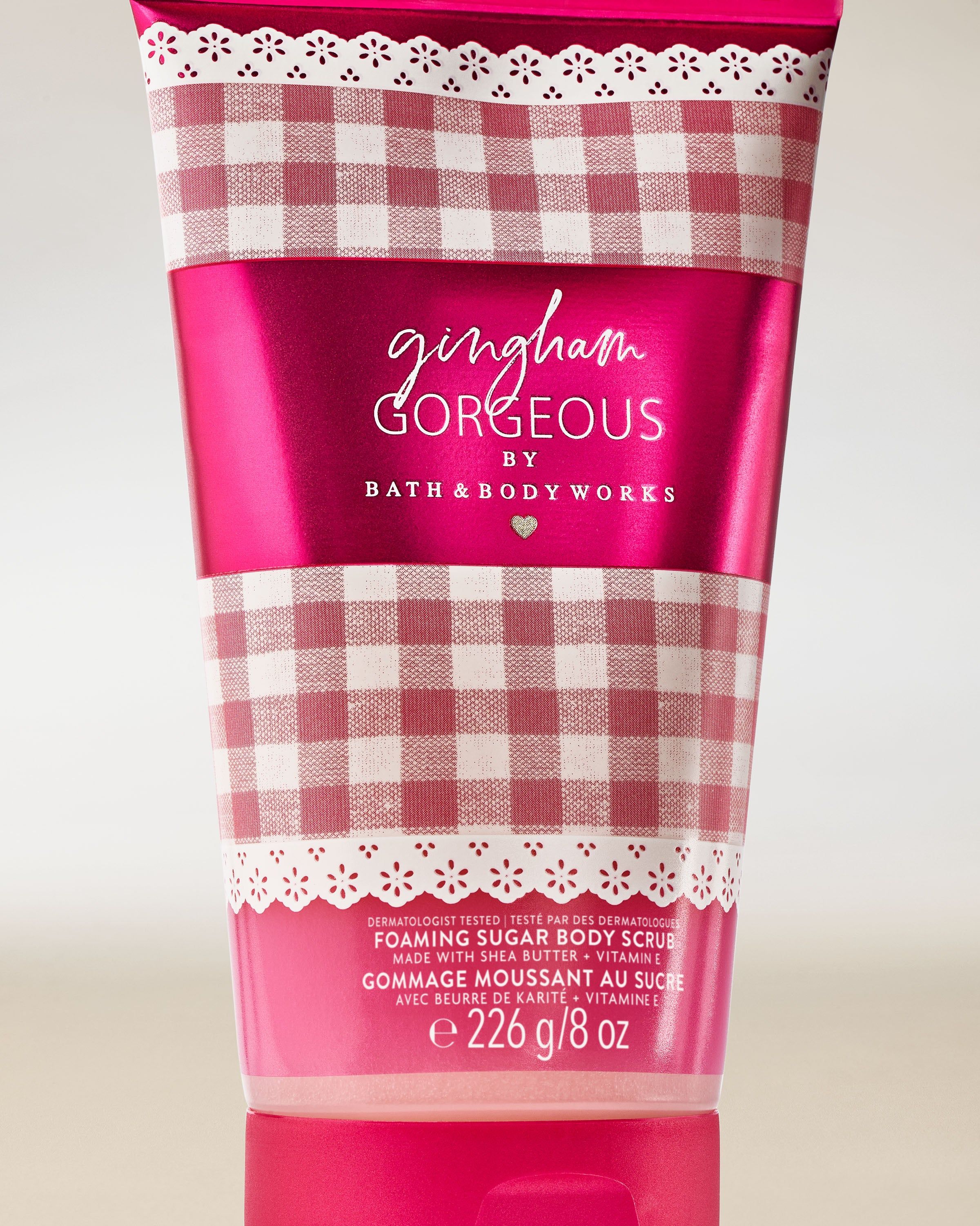 Scrub de corp cu zahăr Bath & Body Works Gingham Gorgeous, în tub roz cu model gingham.