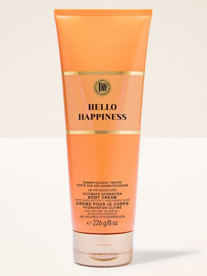 Cremă de corp Hello Happiness Bath & Body Works în tub portocaliu cu accente aurii, plină de energie.