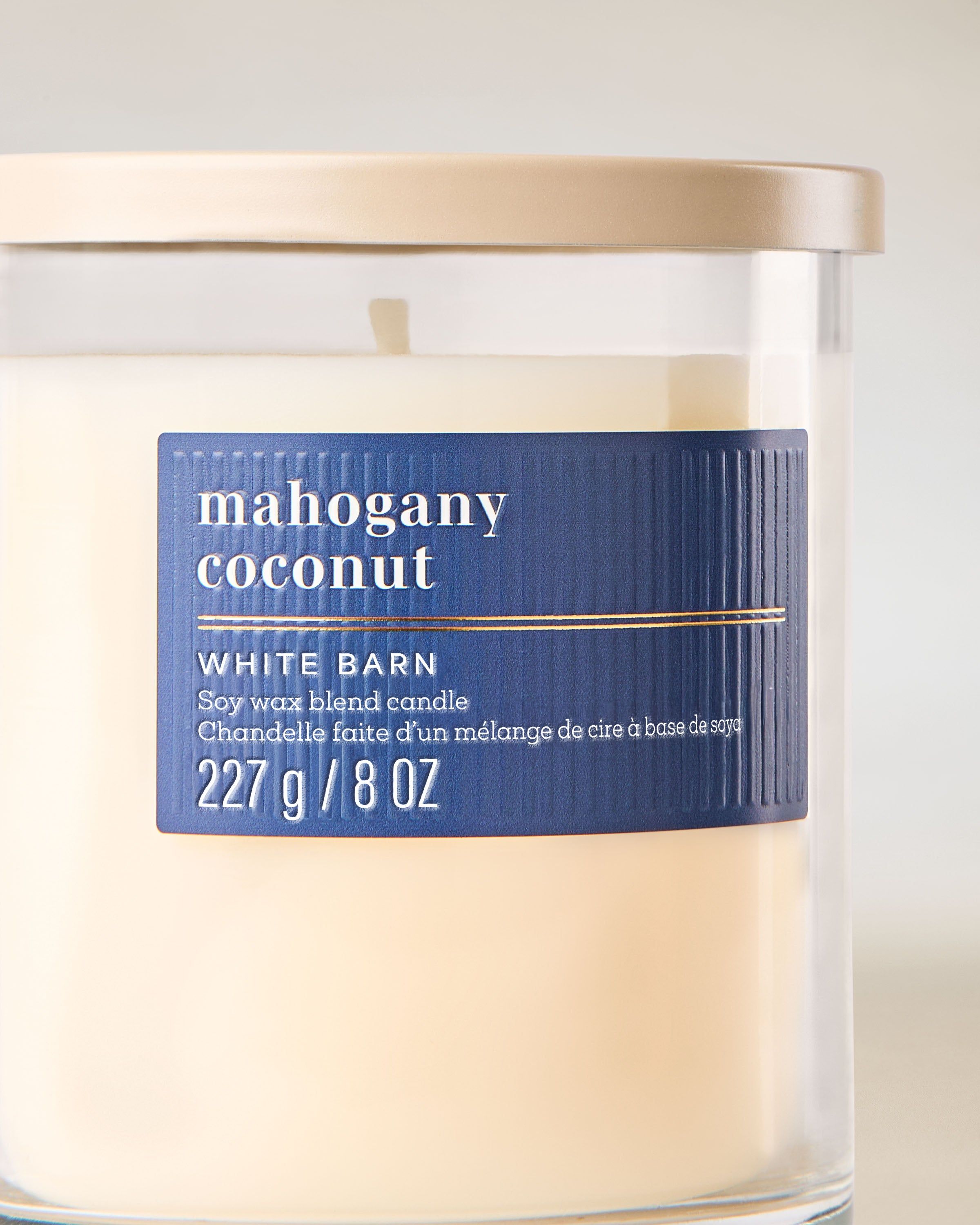 Lumânare Mahogany Coconut White Barn cu aromă caldă, lemnoasă și note cremoase de cocos.