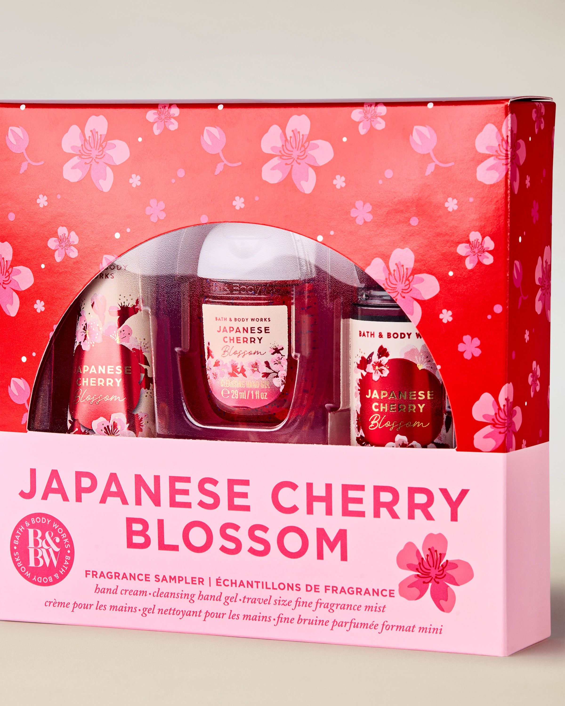 Setul Japanese Cherry Blossom de la Bath & Body Works în cutie roz‑roșie cu model floral.