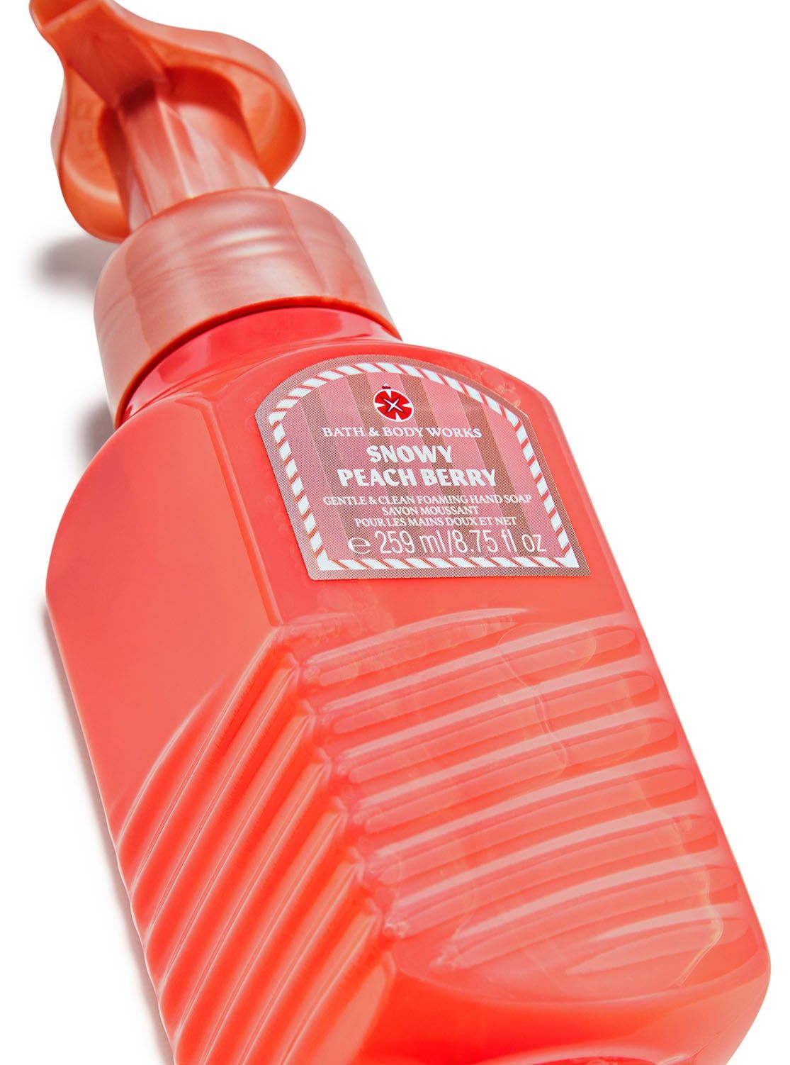 Pěnové mýdlo na ruce Snowy Peach Berry v oranžovo-růžové lahvi se štítkem s větvičkou a sněhovou vločkou. Bath&Body Works.