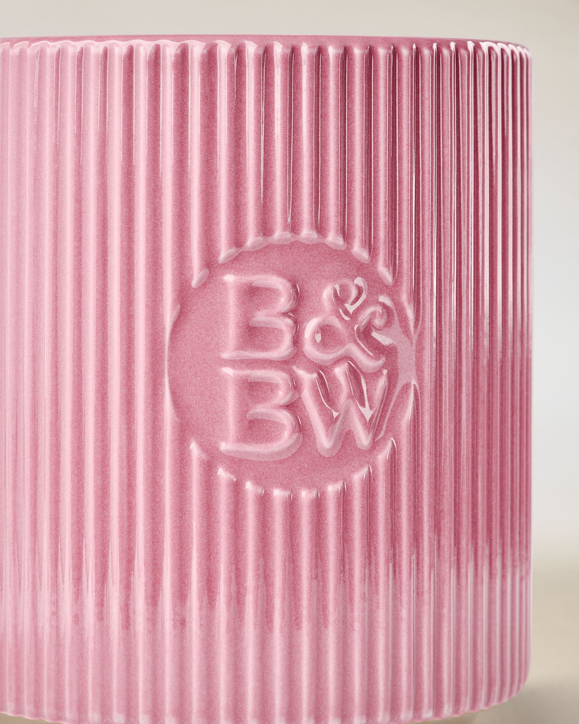 Lumânare Bath & Body Works în suport ceramic roz, cu textură striată.
