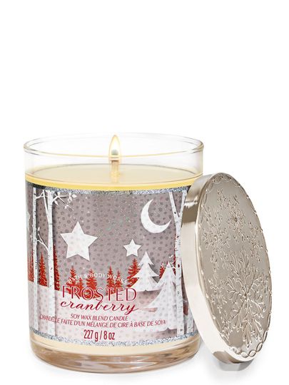 Vonné svíčky „Frosted Cranberry” s etiketou s motivem zimní lesní krajiny, Bath & Body Works.