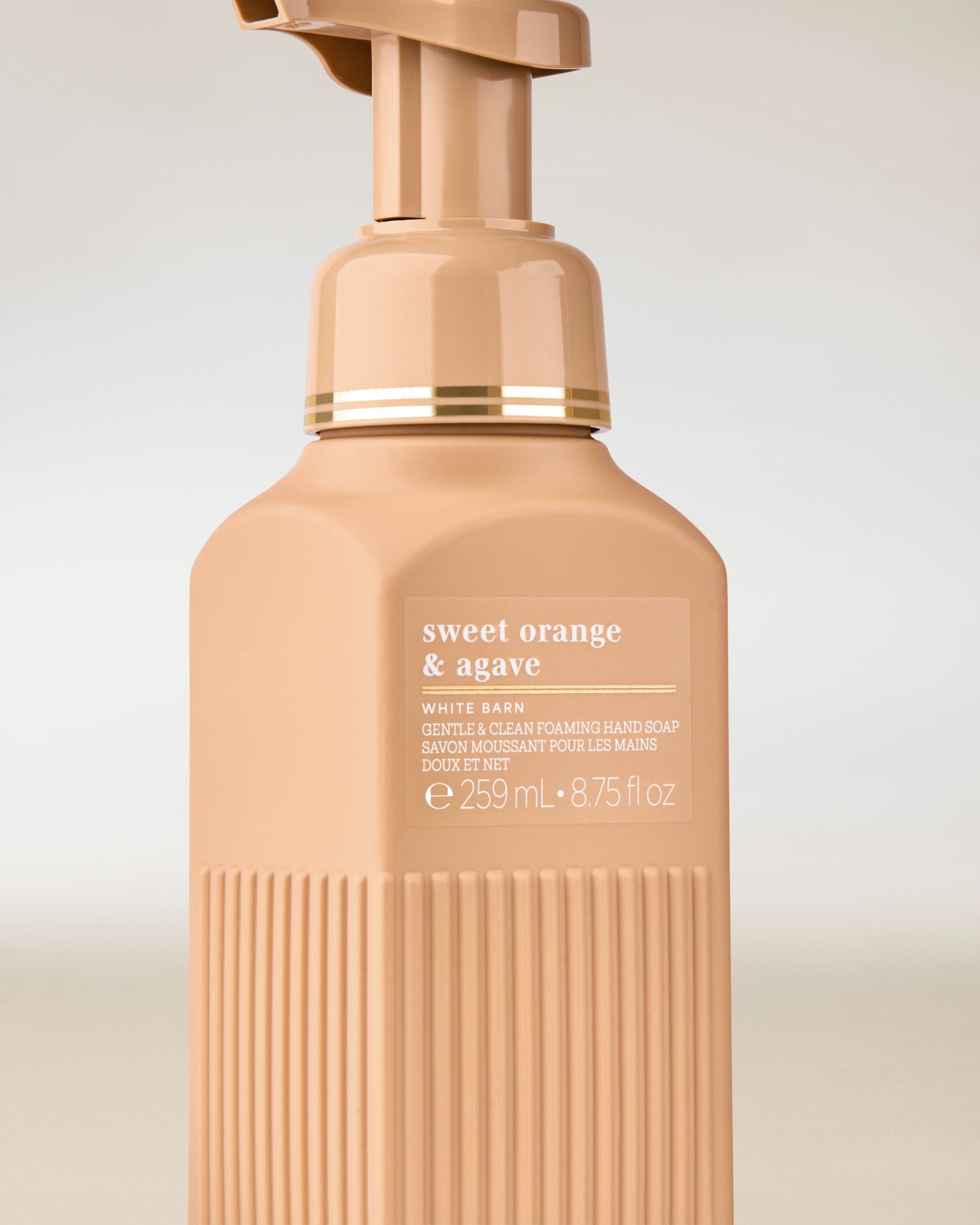 Săpun spumant White Barn „Sweet Orange & Agave” în flacon bej‑caise cu design elegant.
