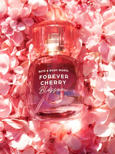 Parfum Bath & Body Works Forever Cherry Blossom, în flacon roz, pe fundal de flori de cireș.