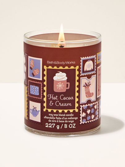 Lumânare parfumată Hot Cocoa & Cream Bath & Body Works cu un fitil aprins și motiv de timbre festive