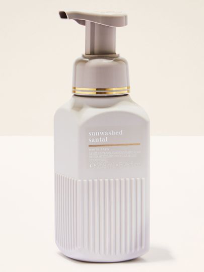 Săpun spumant White Barn „Sunwashed Santal” în flacon crem‑gri, cu design elegant.