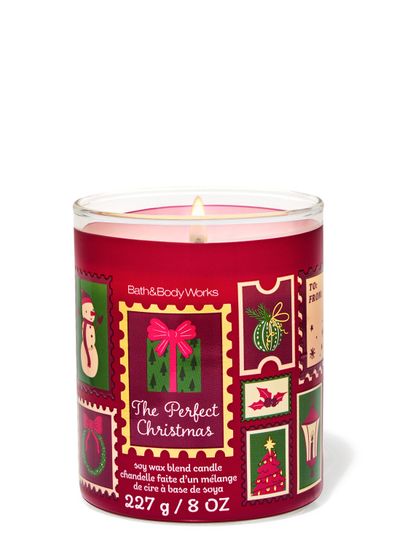 Lumânare parfumată The Perfect Christmas Bath & Body Works cu un fitil aprins și motiv de timbre festive
