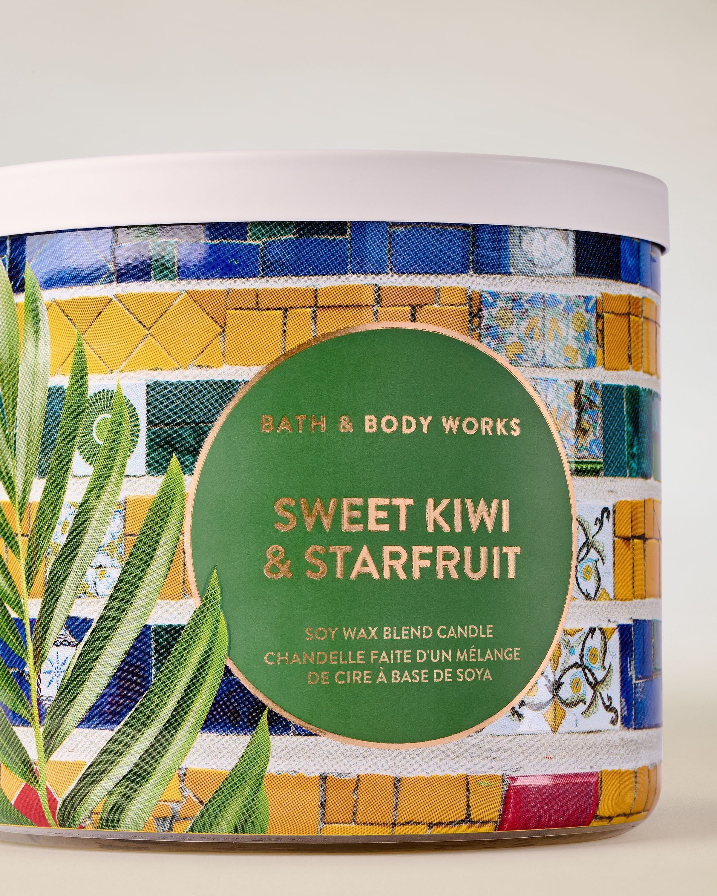 Lumânare cu 3 fitiluri Sweet Kiwi & Starfruit, cu etichetă mozaic colorată și aromă fructată.