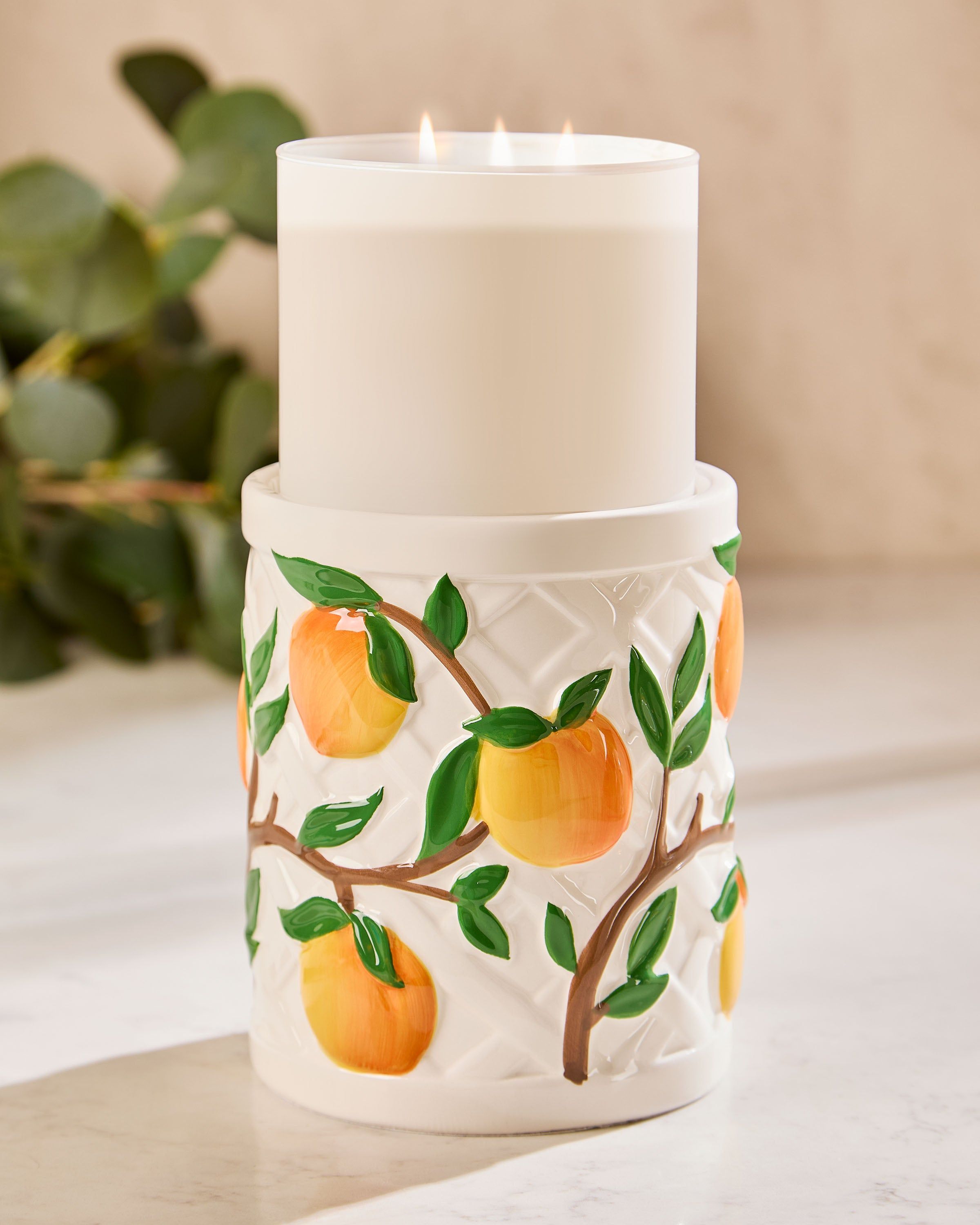 Suport pentru lumânare cu 3 fitiluri Bath & Body Works – ceramică albă reliefată, cu lămâi pictate și frunze verzi.