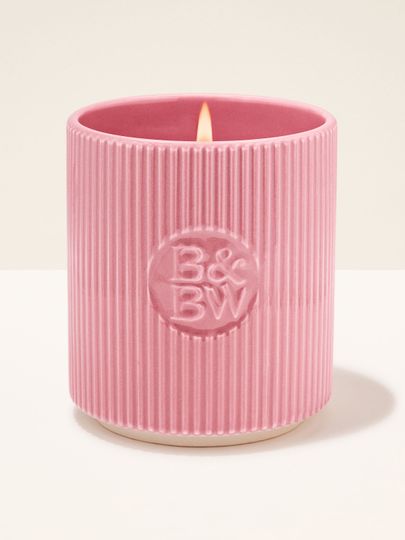 Lumânare Bath & Body Works în suport ceramic roz, cu textură striată.