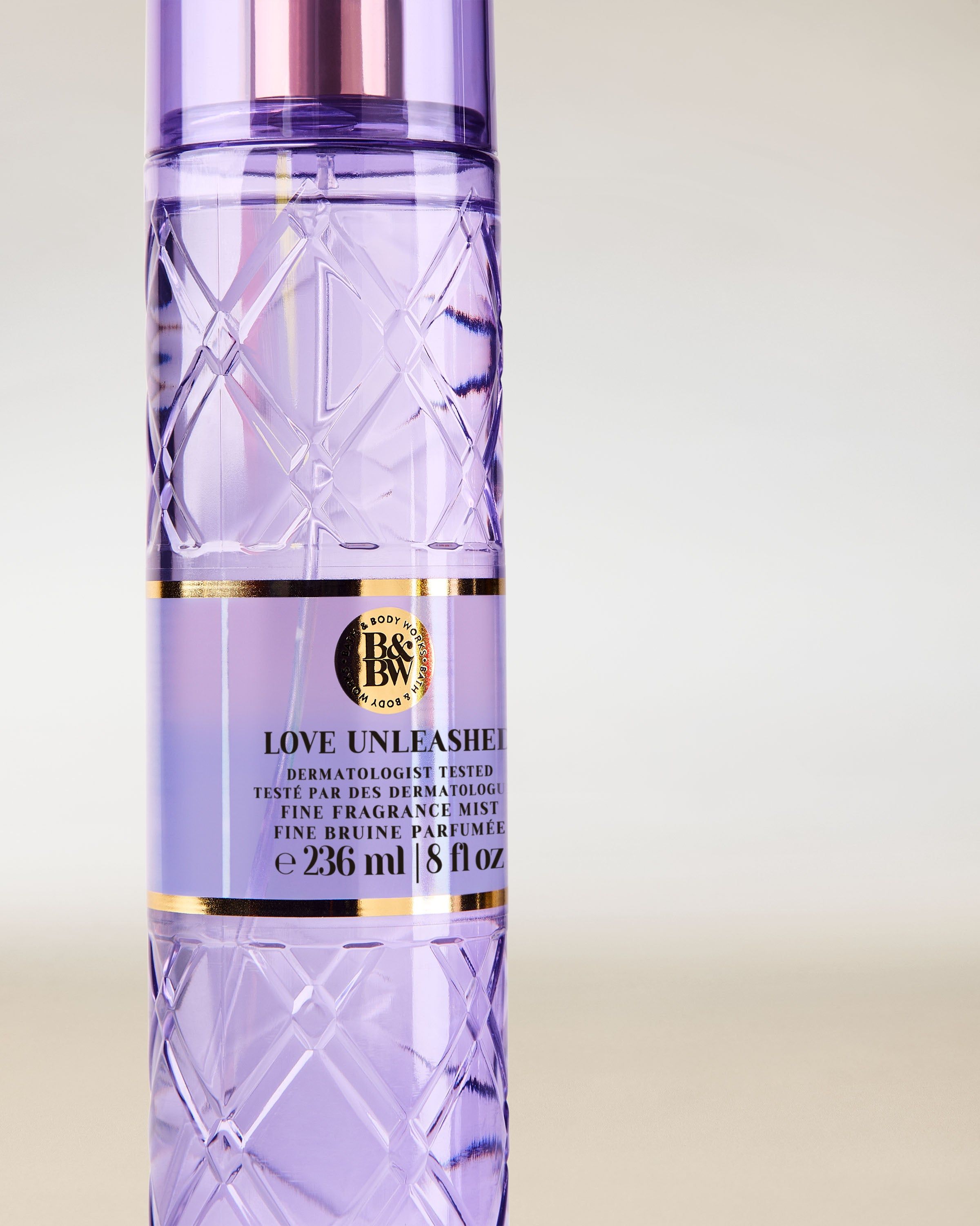 Bath & Body Works Love Unleashed – spray lila în sticlă texturată cu pulverizator roz‑auriu.