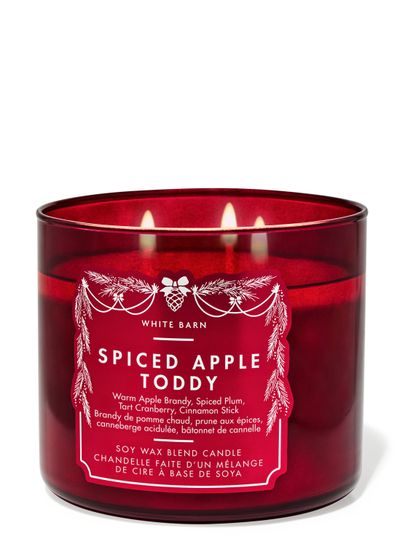 Lumânare parfumată Spiced Apple Toddy White Barn cu trei fitiluri aprinse în recipient roșu din sticlă