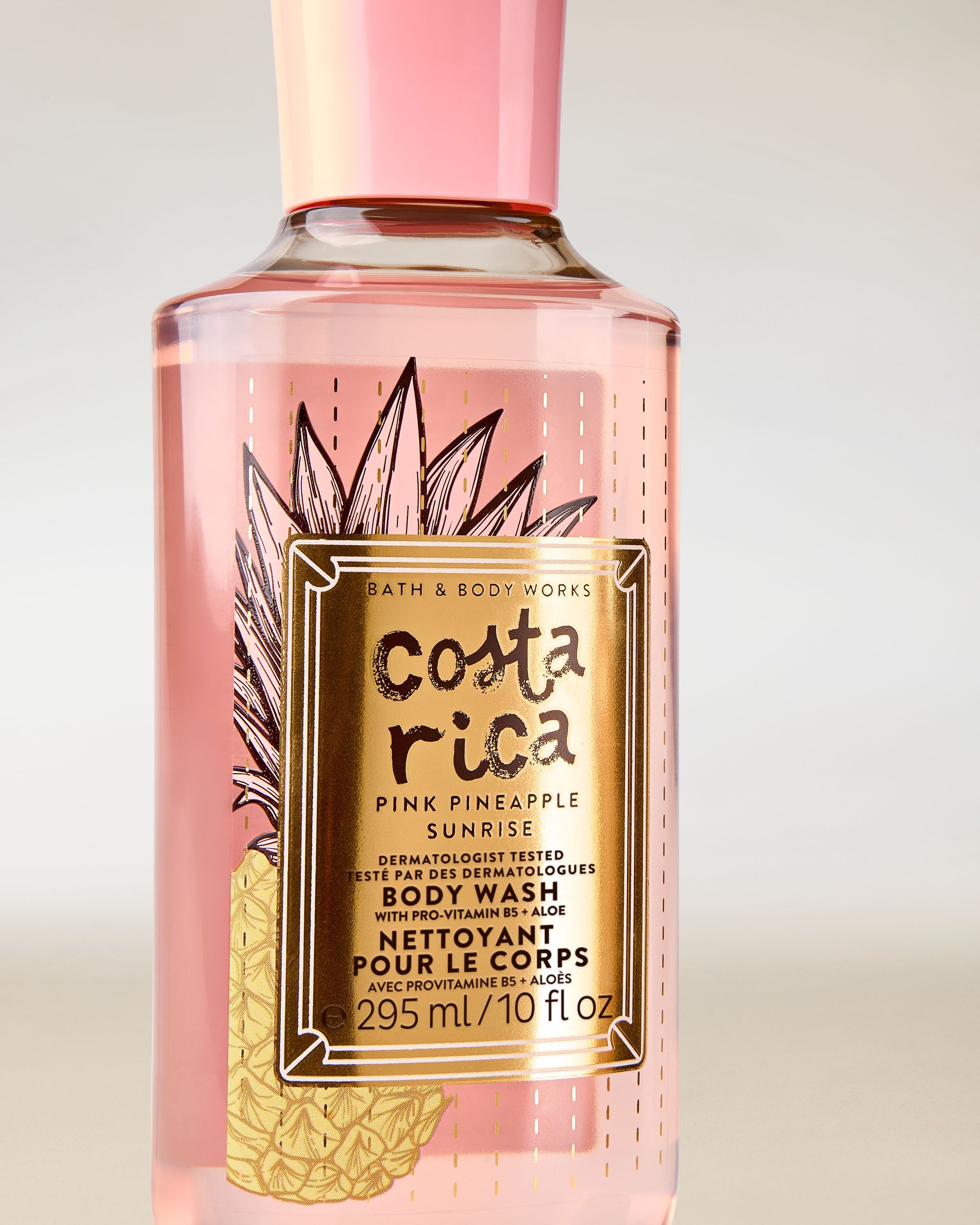 Gel de duș Costa Rica Pink Pineapple Sunrise în sticlă roz, cu etichetă tropicală și capac roz.