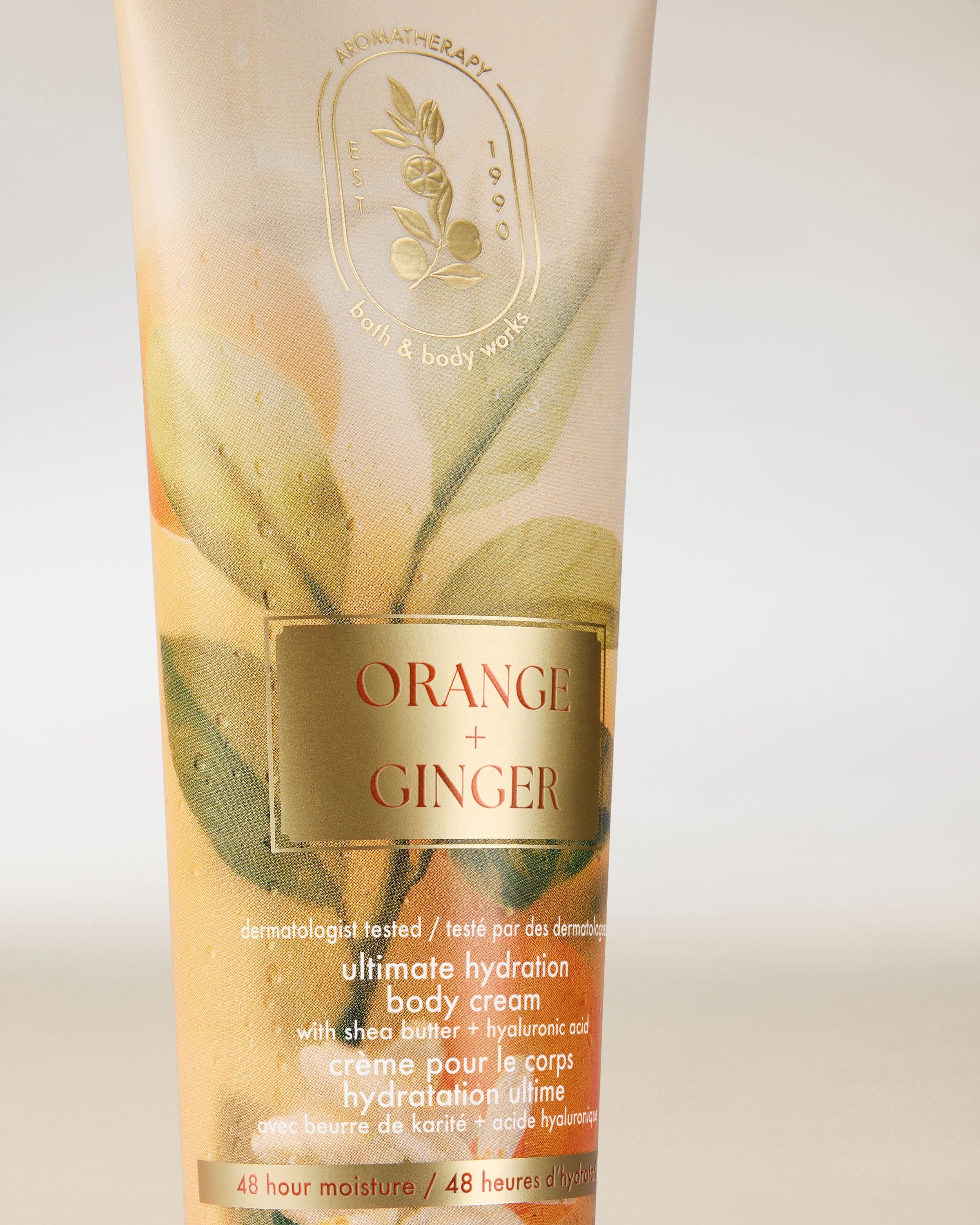 Cremă de corp Bath & Body Works Aromatherapy Orange + Ginger 226 g, în tub deschis cu decor vegetal.