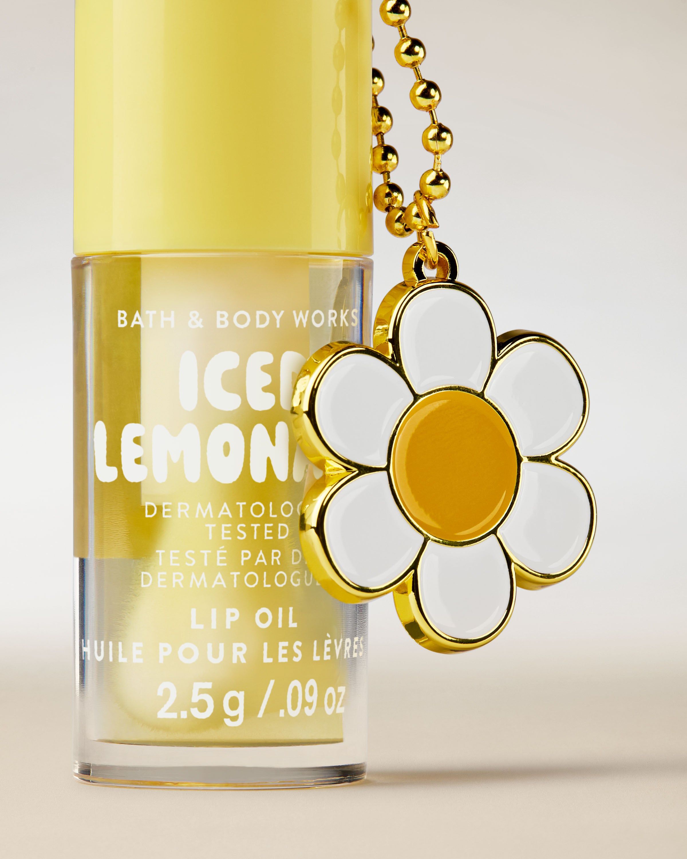 Ulei de buze Bath & Body Works Iced Lemonade 2,5 g, în ambalaj galben cu breloc decorativ.