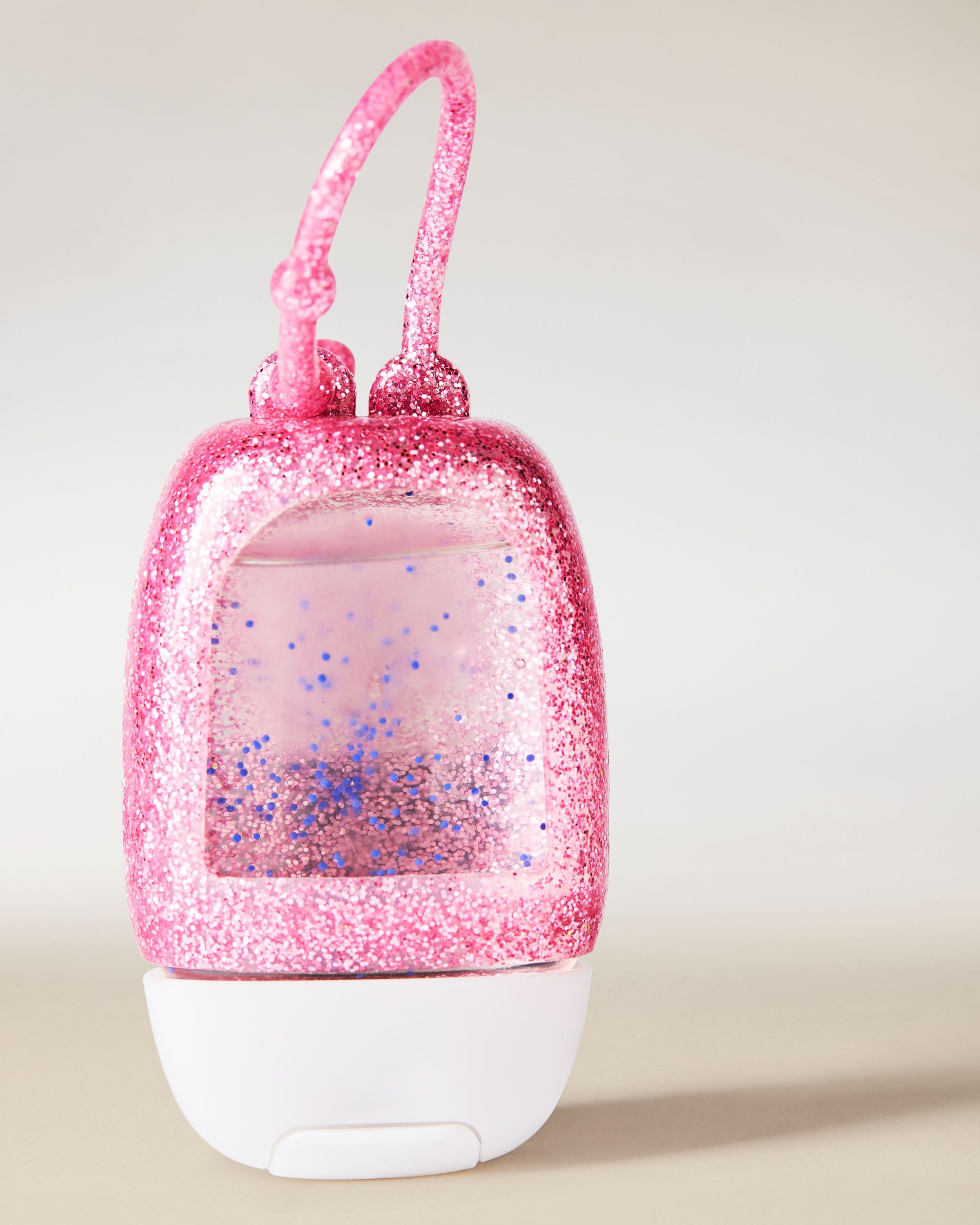 Suportul strălucitor PocketBac, într-o nuanță intensă de roz, realizat din material flexibil pentru atașarea ușoară a gelului antibacterian mini.