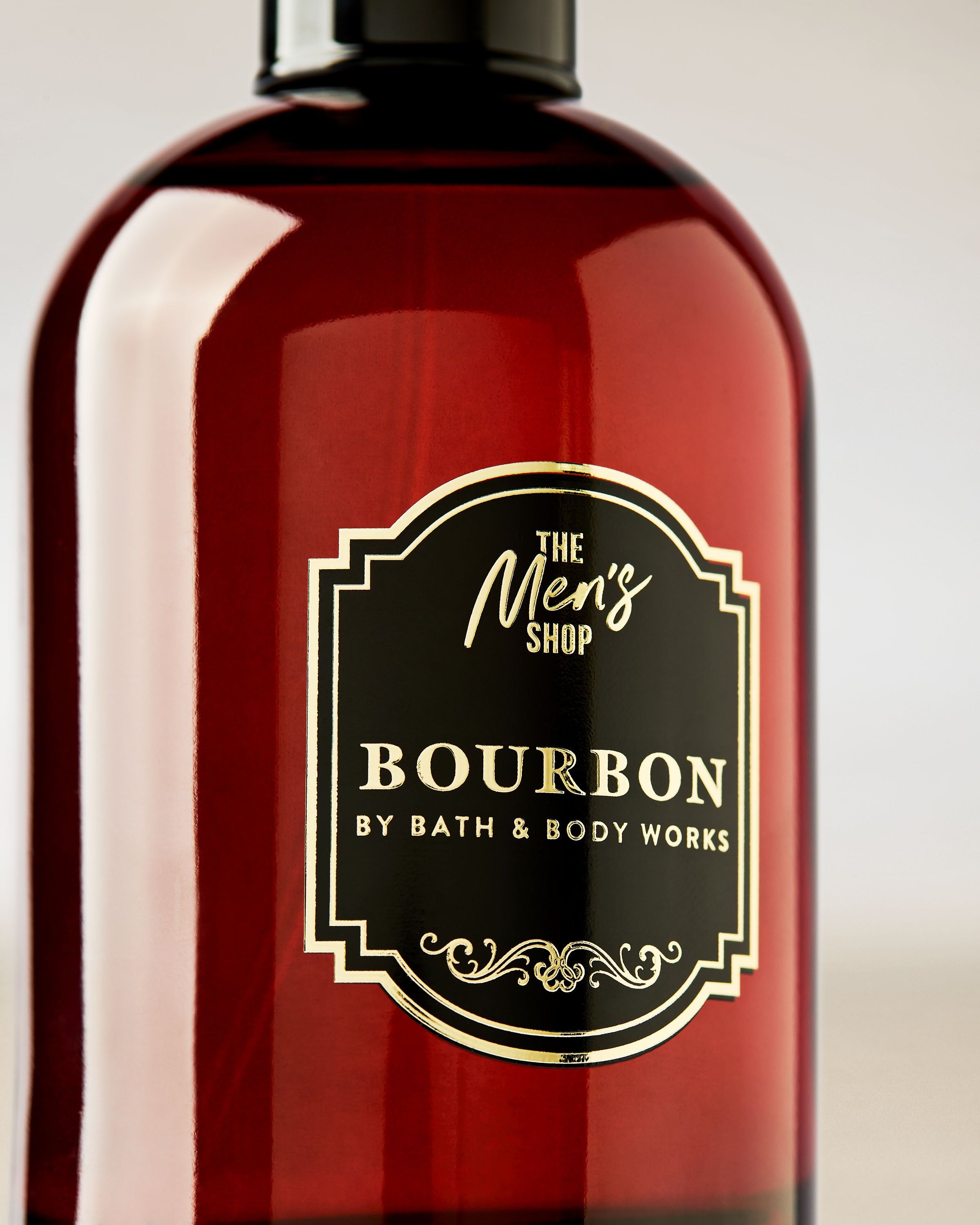 Bath & Body Works Bourbon – flacon roșu închis cu capac negru și etichetă decorativă, stil Men’s Shop.