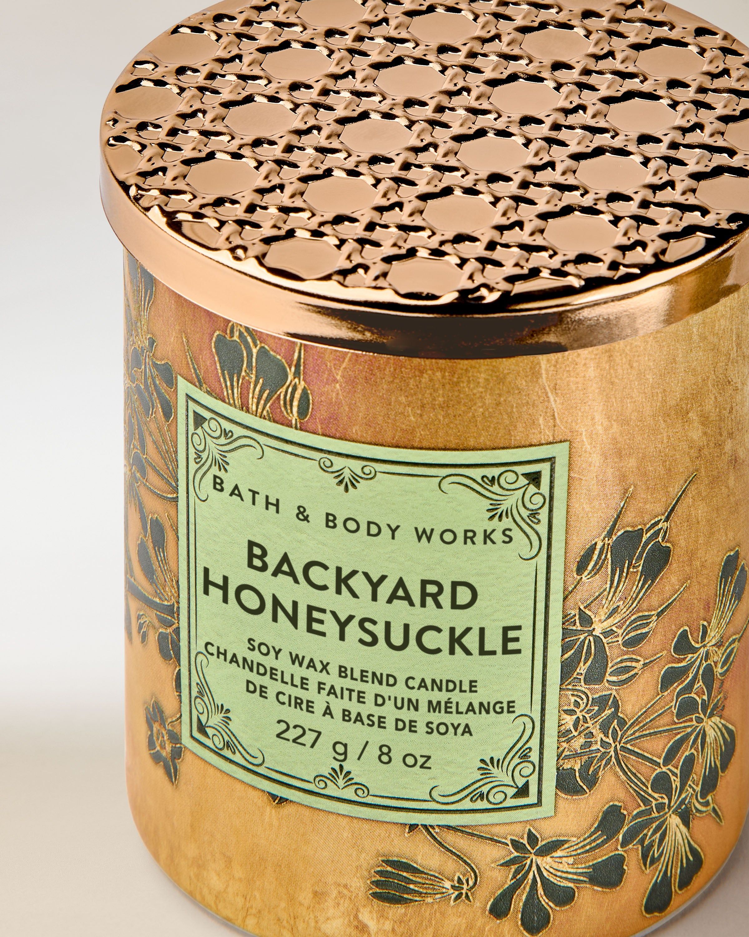 Bath & Body Works Backyard Honeysuckle – lumânare cu ceară de soia și design floral auriu.