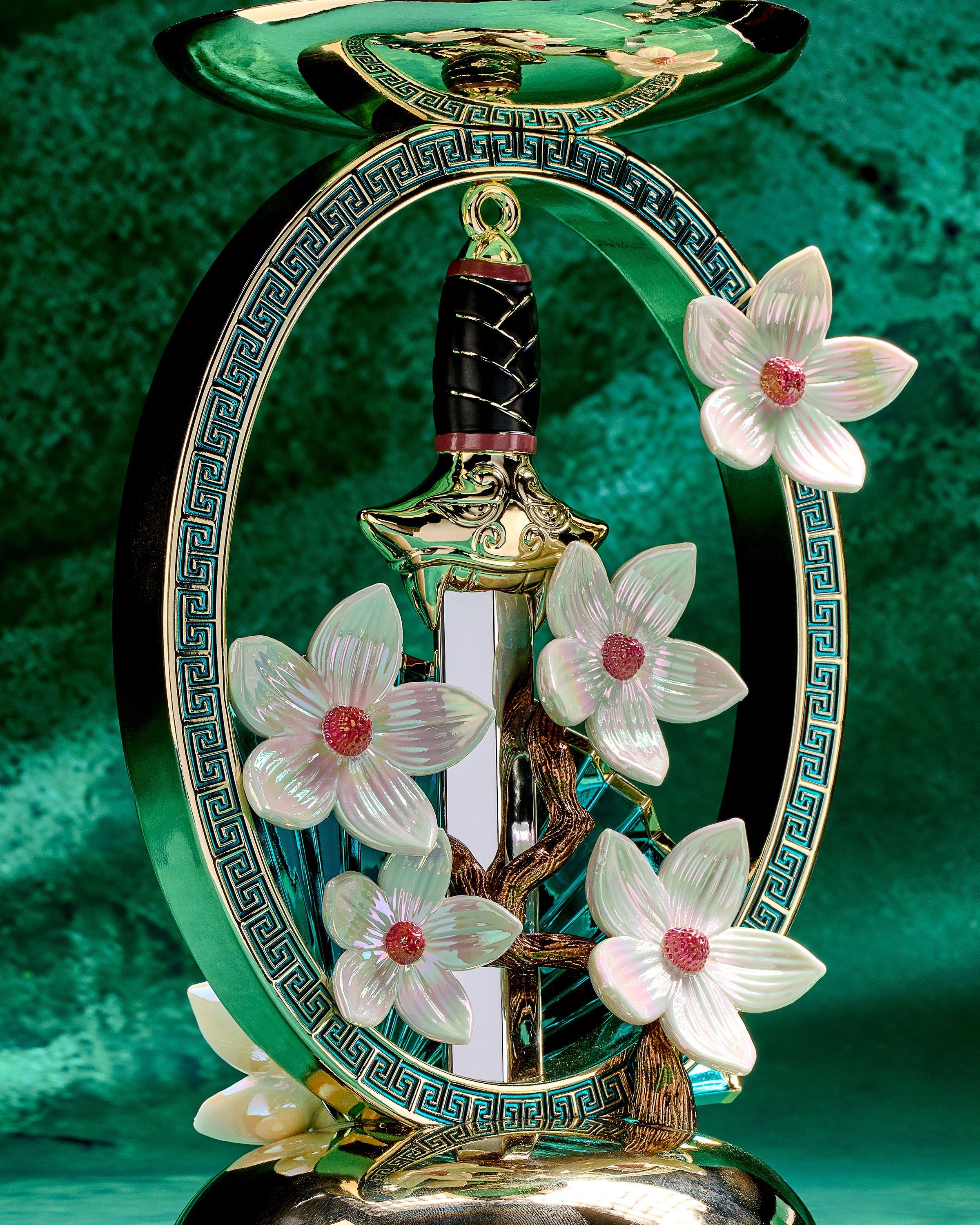 Suport Mulan pentru lumânare cu 3 fitiluri, cu sabie aurie, evantai și flori de magnolie într‑un cadru decorativ.