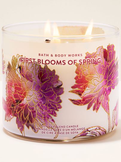 Bath & Body Works First Blooms of Spring – lumânare cu 3 fitiluri în pahar alb, cu detalii florale auriu‑roz și parfum de primăvară.