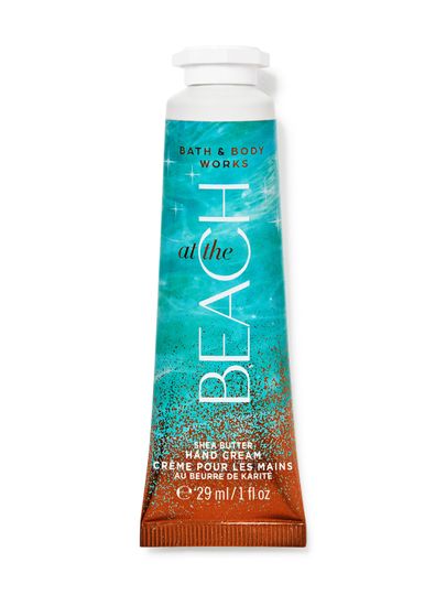 Cremă de mâini Bath&Body Works At the Beach. Tub mic, metalic, turcoaz-portocaliu, cu sclipici și inscripții.