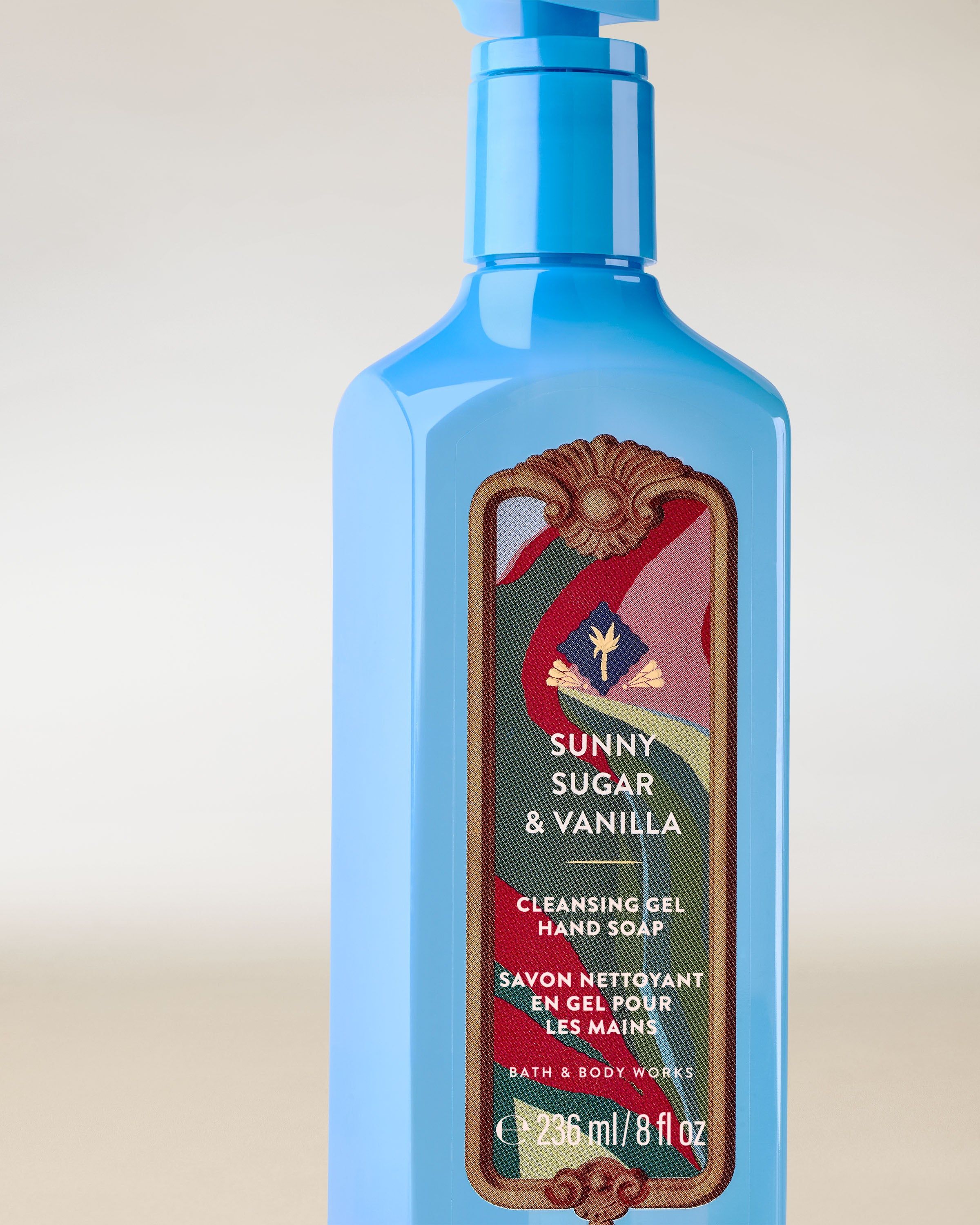 Sunny Sugar & Vanilla – gel pentru mâini albastru, cu pompă și etichetă decorativă în tonuri calde și dulci.