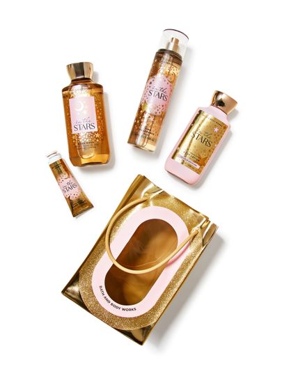 Set cadou Bath & Body Works In The Stars: gel, spray, loțiune, cremă de mâini și geantă decorativă aurie.