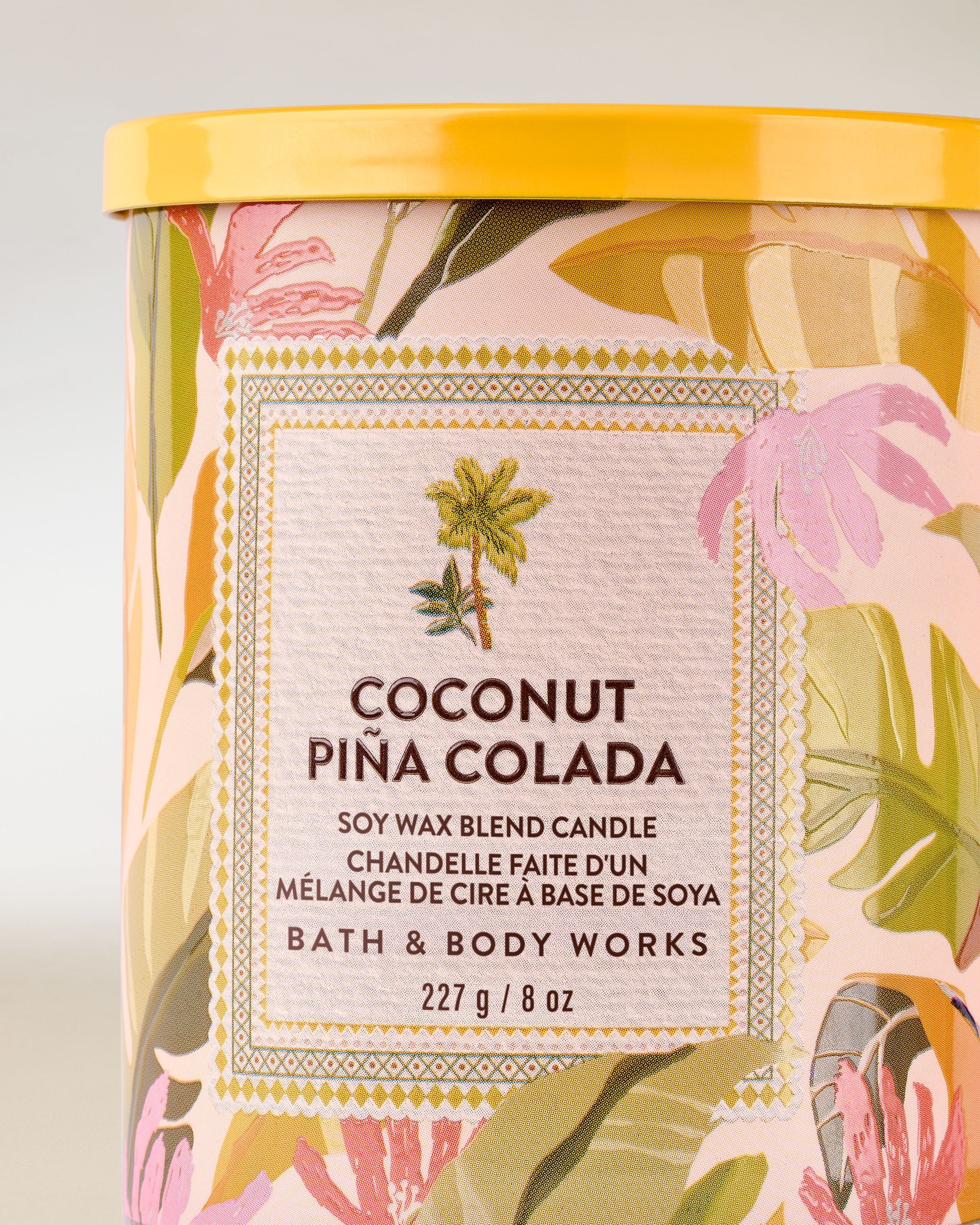 Lumânare parfumată Coconut Piña Colada de la Bath & Body Works, borcan din sticlă cu etichetă tropicală colorată.