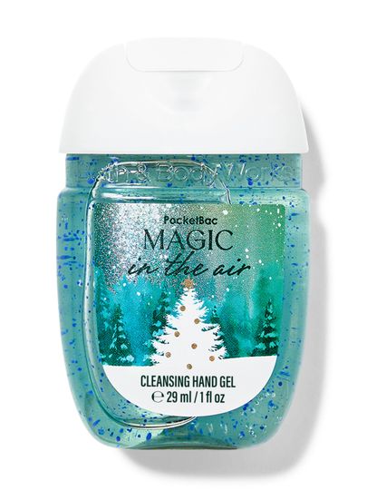 Cestovní čisticí gel na ruce „Magic in the Air“ v modrém obalu s motivem zasněžených vánočních stromků. Bath & Body Works.