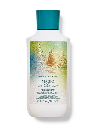 Bílé tělové mléko s motivem zimního lesa a nápisem "Magic in the air", Bath & Body Works.