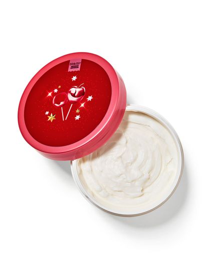 Otevřená nádobka s tělovým máslem Winter Candy Apple, s červeným víčkem s motivem jablek. Bath & Body Works.