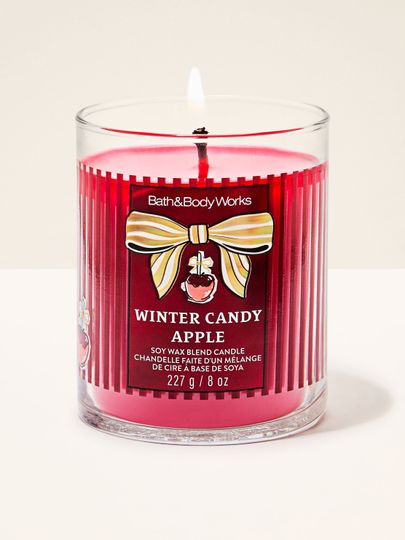 Lumânare parfumată Winter Candy Apple Bath & Body Works cu un fitil aprins și motiv de măr glazurat