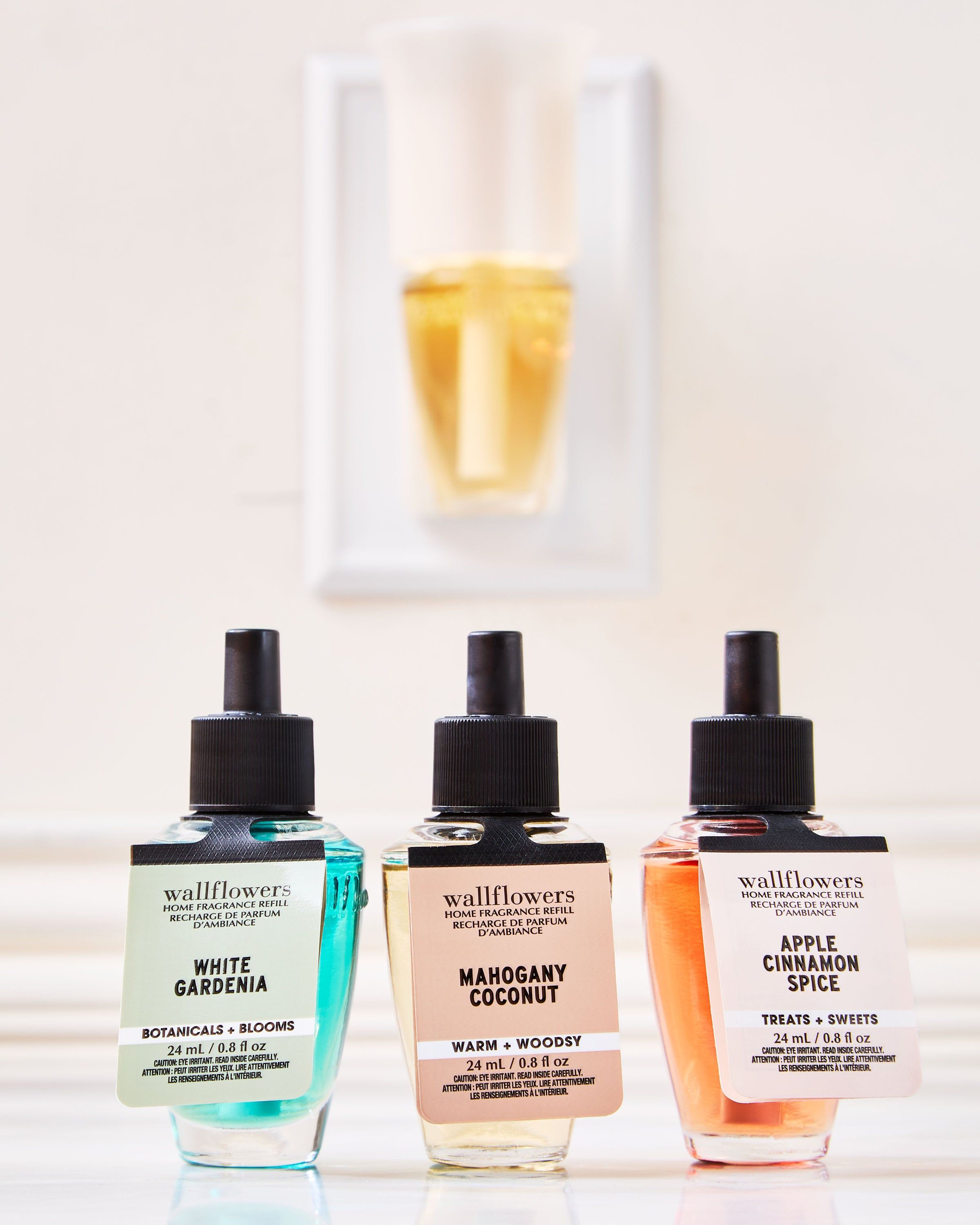 Set de reumpleri Wallflowers: White Gardenia, Mahogany Coconut și Apple Cinnamon Spice în sticluțe elegante.