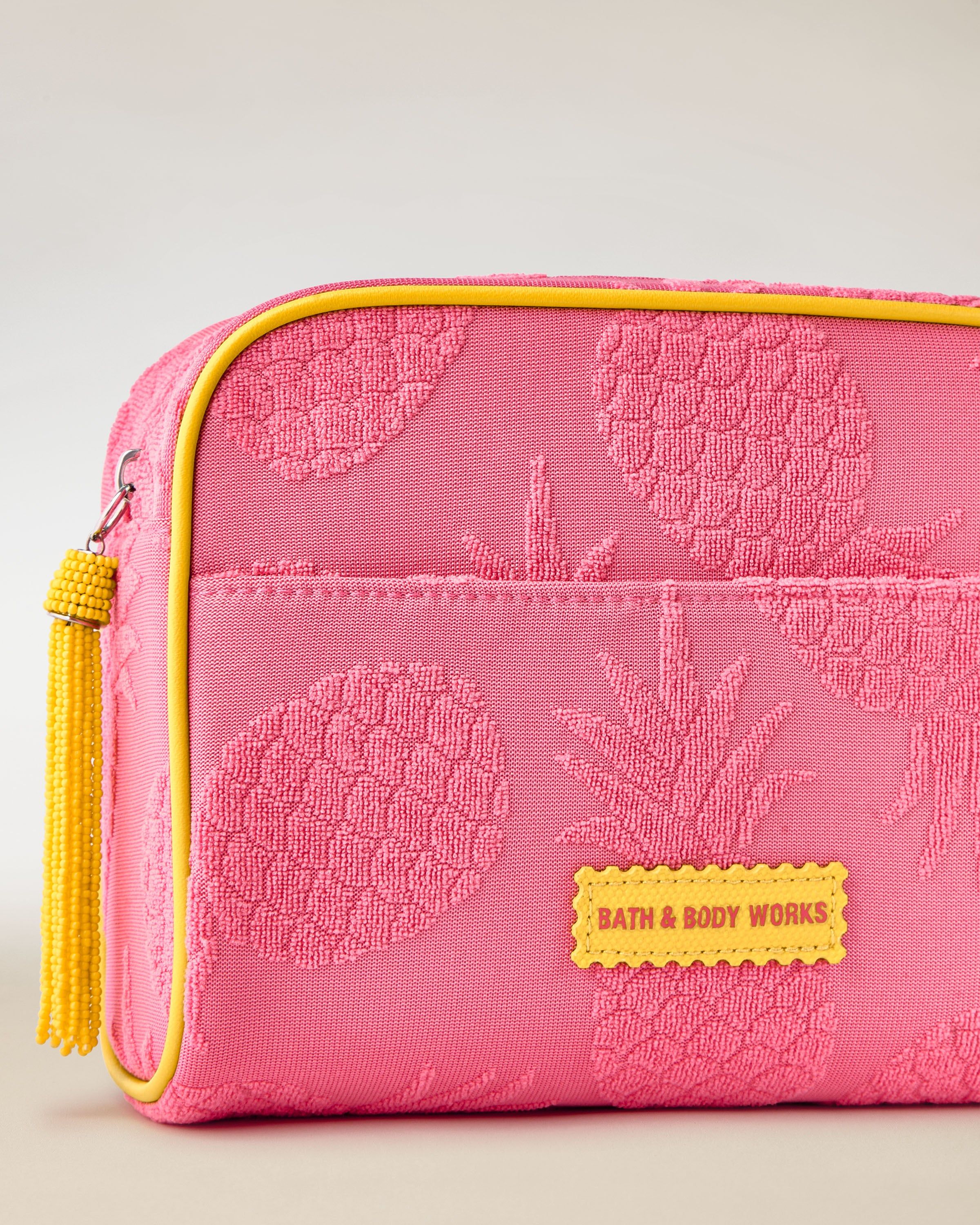 Pungă cosmetică roz Bath & Body Works cu model ananas și accente galbene.