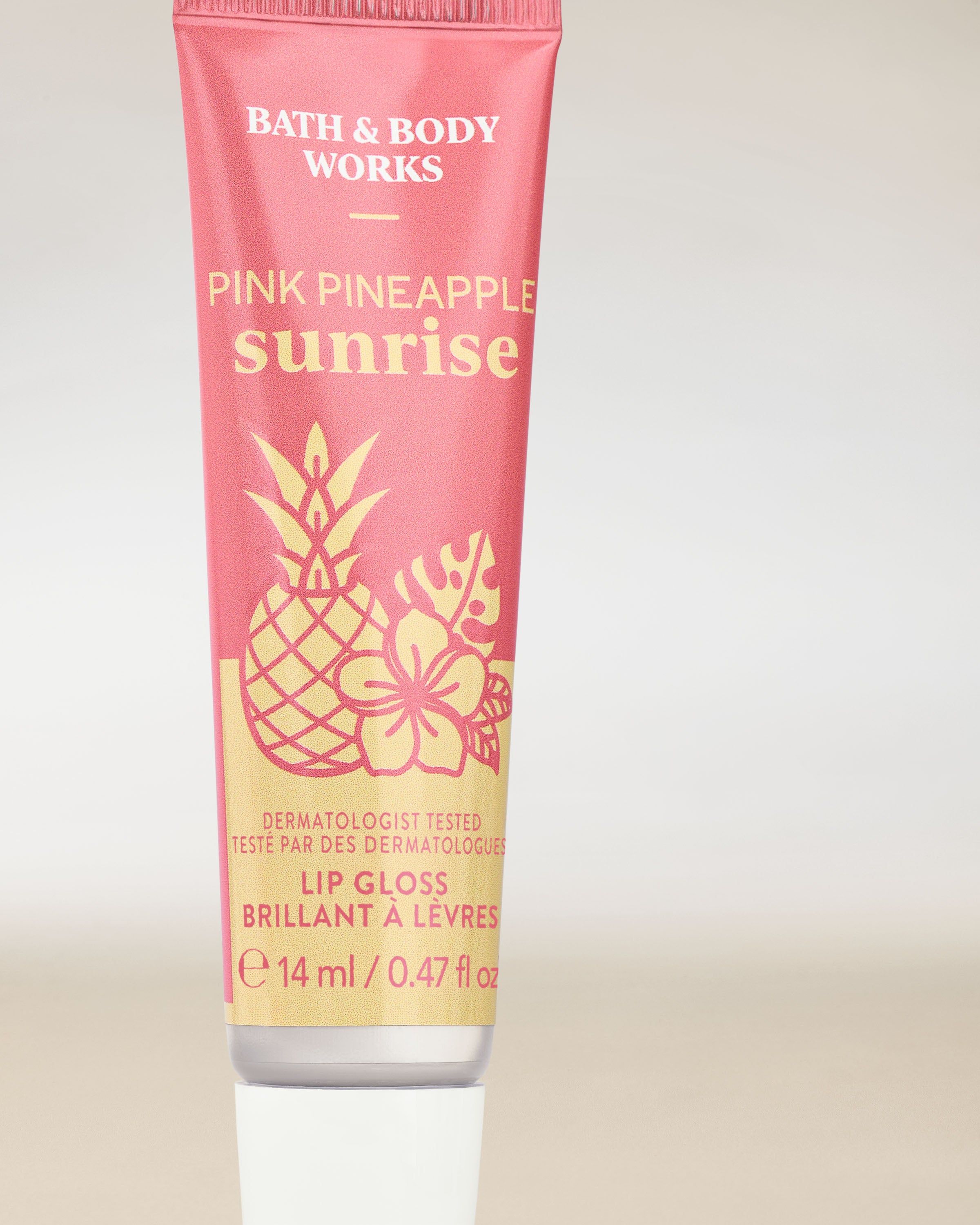 Pink Pineapple Sunrise – błyszczyk do ust w różowym opakowaniu z tropikalną grafiką ananasa i hibiskusa.