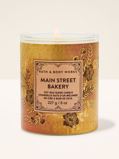 Bath & Body Works Main Street Bakery – lumânare 227 g în ambalaj auriu‑maroniu cu detalii florale reliefate.
